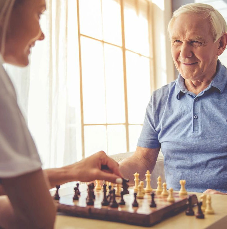 A woman and an old man playing chess